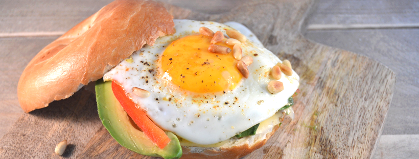 Bagel met een gebakken eitje, avocado en paprika