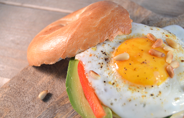 Bagel met een gebakken eitje, avocado en paprika