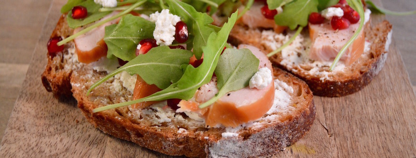 Belegde broodjes met gerookte kip, geitenkaas en granaatappel